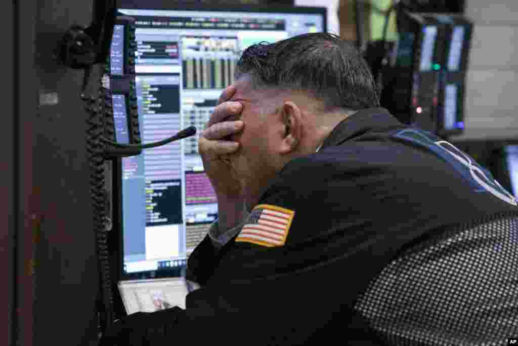 A trader works in his booth on the floor of the New York Stock Exchange, in New York.