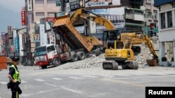 2024年4月4日，工作人员正在台湾花莲市一个街区应对大地震产生的房屋倾塌。