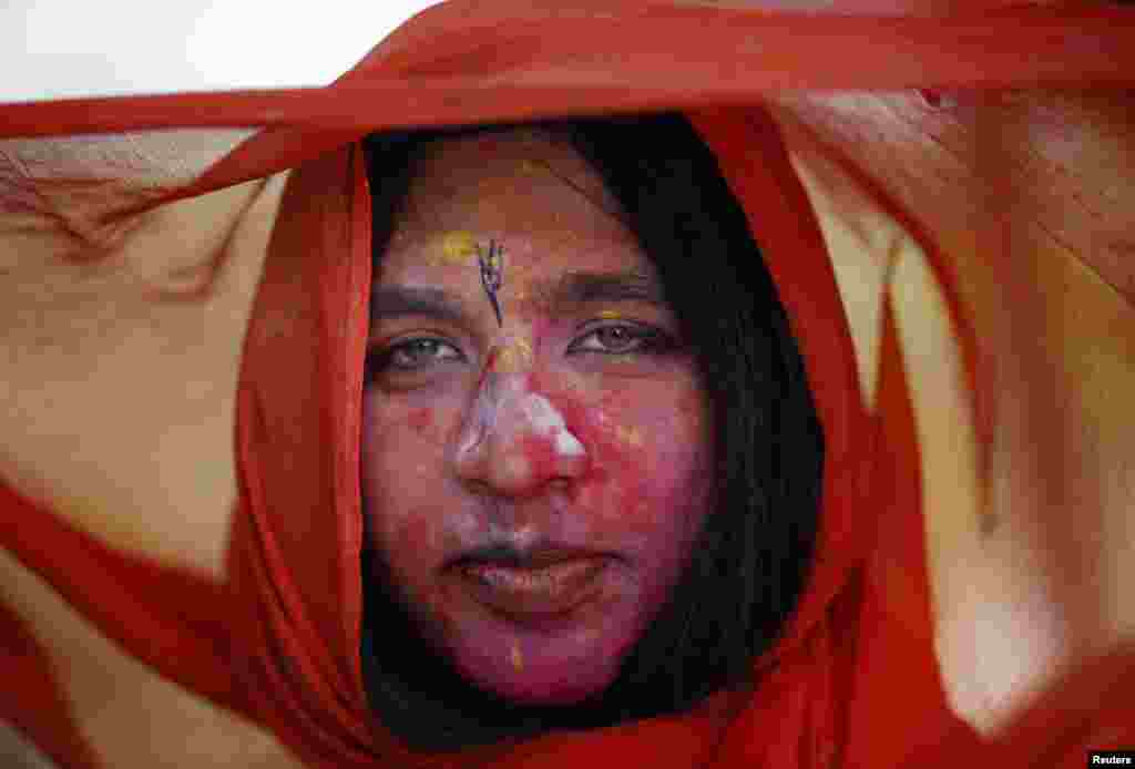 Một ủng hộ viên của Đảng Dân chủ Nhân dân ủng hộ người Kurd ra dấu hiệu chiến thắng trong khi những người khác cầm hình của lãnh đạo phiến quân người Kurd đang bị tù Abdullah Ocalan, trong một cuộc tập hợp ở Istanbul, Thổ Nhĩ Kỳ, một ngày sau cuộc bầu cử quốc hội