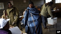 A Lesotho man wearing a traditional blanket prepares to vote at the Mpho primary school in Maseru, Lesotho, May 26, 2012.