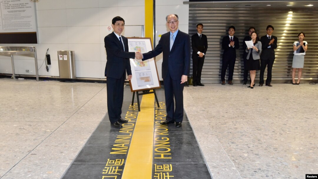 在香港西九龙高铁总站交接仪式上香港运输及房屋局局长陈帆（右）与中国深圳市人民政府的官员握手。（2018年9月3日）