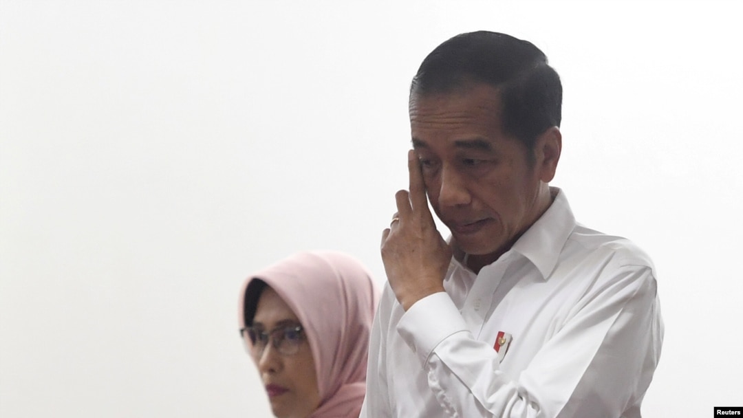 Presiden Indonesia Joko Widodo bersama dengan Plt Dirut PT PLN Perserto Sripeni Inten Cahyani (kiri), setibanya di kantor Perusahaan Listrik Negara (PLN) Pusat jakarta, pasca pemadaman listrik besar-besaran di Jakarta, 5 Agustus 2019.