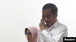 Presiden Indonesia Joko Widodo bersama dengan Plt Dirut PT PLN Perserto Sripeni Inten Cahyani (kiri), setibanya di kantor Perusahaan Listrik Negara (PLN) Pusat jakarta, pasca pemadaman listrik besar-besaran di Jakarta, 5 Agustus 2019.