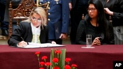 La presidente interina de Bolivia Jeanine Añez, firma la ley de régimen excepcional y transitorio que establece las normas para la convocatoria a nuevas elecciones con nuevo TSE, nuevas alianzas y candidatos, que no incluyen a Evo Morales y Álvaro García Linera. Nov.24, 2019. AP.