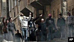 Anti-Syrian government protesters flash V sign as they protest in the southern city of Daraa, March 23, 2011.