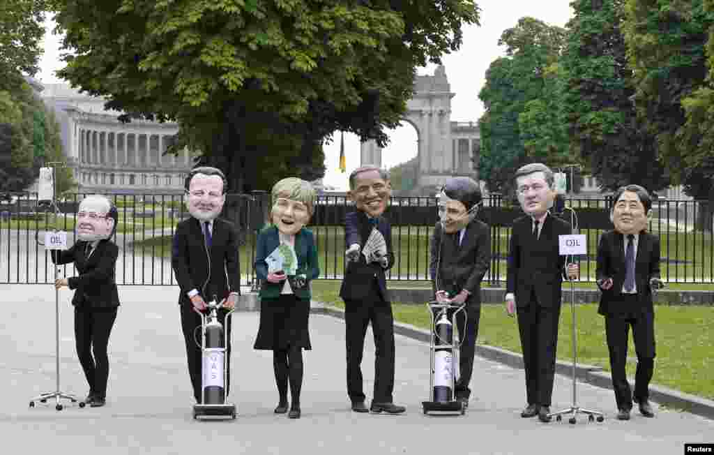 Oxfam&#39;s activists wear masks depicting leaders of the countries members of the G7, (L-R) French President Francois Hollande, British Prime Minister David Cameron, German Chancellor Angela Merkel, U.S. President Barack Obama, Italian Prime Minister Matteo Renzi, Canadian Prime Minister Stephen Harper and Japanase Prime Minister Shinzo Abe, during a protest called &quot;Energy dependency and wealth inquality&quot; outside the European Council in Brussels, Belgium.