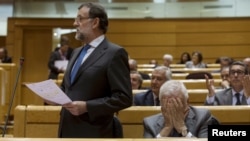 Spain's Prime Minister Mariano Rajoy, left, speaks as Foreign Minister Jose Manuel Garcia-Margallo reacts during the cabinet control session at the Senate in Madrid, Spain, May 26, 2015. 