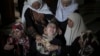 Palestinian relatives of the five members of the Hamad family who were killed in an Israeli missile strike late Tuesday grieve in the family house during their funeral in town of Beit Hanoun, northern Gaza Strip, July 9, 2014. 