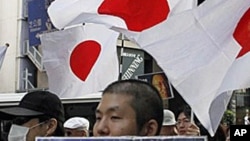 A Japanese protester holding a placard with a message reading, "Free (Nobel Peace Prize winner) Dr. Liu Xiaobo," marches down streets in central Tokyo as an estimated 2,500 protesters take to the streets in a protest against China, 16 Oct 2010.