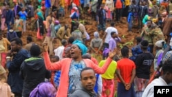 This grab made from a handout footage released by the Gofa Zone Government Communication Affairs Department on July 23, 2024, shows people standing at the bottom of a landslide that occurred in the Geze-Gofa district.