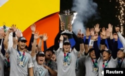 FILE - Shohei Ohtani (C) and team Japan celebrate with the World Baseball Classic trophy after defeating the U.S. in the World Baseball Classic at LoanDepot Park on March 21, 2023. (Rhona Wise-USA TODAY Sports)