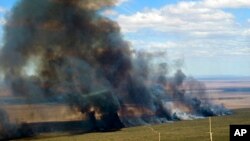 ARCHIVO - El humo se eleva desde un campo en llamas en medio de altas temperaturas y fuertes vientos entre Puerto Madryn y Puerto Pirámides en la Patagonia argentina, el martes 4 de enero de 2022. 