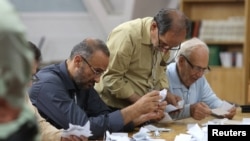 Para petugas pilpres menghitung surat suara di sebuah tempat pemungutan suara setelah pemungutan suara untuk memilih pengganti mendiang Presiden Ebrahim Raisi, selesai pada Sabtu, 29 Juni 2024. (Foto: Majid Asgaripour/West Asia News Agency via Reuters)