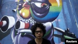 Thai graffiti artist Asin Acid poses near his graffiti in Bangkok, Thailand, March 7, 2016. 