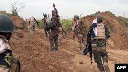 Iraqi Shi'ite fighters from the Furqat al-Abbas brigades take up their position during an operation to retake the town of al-Bashir, near Kirkuk, from the Islamic State group, April 10, 2016.