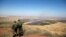 FILE - Israeli soldiers look at the Syrian side of the Israel-Syria border on the Israeli-occupied Golan Heights, Israel, July 7, 2018.