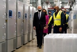 President Joe Biden walks past freezers used to store Pfizer-BioNtech's COVID-19 vaccine as he tours a Pfizer manufacturing site, Feb. 19, 2021, in Portage, Mich.