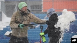 Trabajadores retiran la nieve del Estadio Highmark de Orchard Park, Nueva York., el domingo 14 de enero de 2024.