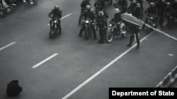 在网上流传的画面显示一名伊朗抗议者面对骑摩托车赶到现场驱逐人群的伊朗安全部队，勇敢地静坐在德黑兰街头，拒绝离开。美国国务院在X平台的波斯语账号转发了这幅图像。