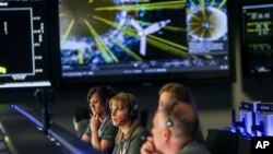 FILE - Staff members of Juno Mission watch on before the solar-powered Juno spacecraft went into orbit around Jupiter, at NASA's Jet Propulsion Laboratory in Pasadena, Calif., on July 4, 2016. (AP Photo/Ringo H.W. Chiu)