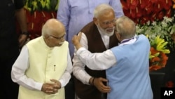 PM Inida, Narendra Modi, kedua dari kanan, memeluk pemimpn senior Bharatiya Janata Party, M.M. Joshi sedangkan L.K. Advani, kiri, sebagai pemimpin aliansi partai yang berkuasa menyimak, New Delhi, 25 Mei 2019 (foto: AP Photo/Manish Swarup)