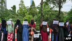Somali&#39;s women refugees hold placards as they gather to protest their living conditions in Malaysia, outside the office of the United Nations High Commissioner For Refugees (UNHCR) in Kuala Lumpur.