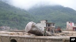 在同样遭受暴雨袭击的贵州省，一民警6月6日走过该省望谟县一座受灾桥梁