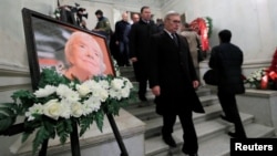 People walk past a picture of the founder of Russia's oldest human rights group and Sakharov Prize winner, Lyudmila Alexeyeva, during her memorial service in Moscow, Russia, Dec. 11, 2018.