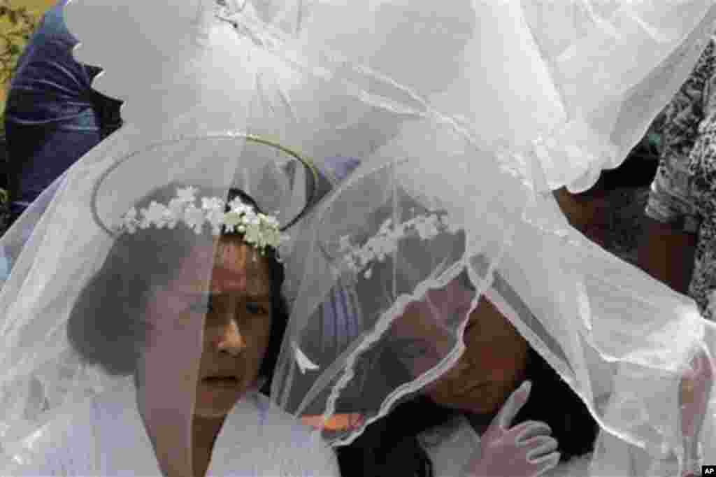 Girls dressed as angels participate in the reenactment of the Passion of Christ on Good Friday during Holy Week celebrations in Alagansi, on the outskirts of Quito, Ecuador, Friday April 6, 2012. (AP Photo/Dolores Ochoa)