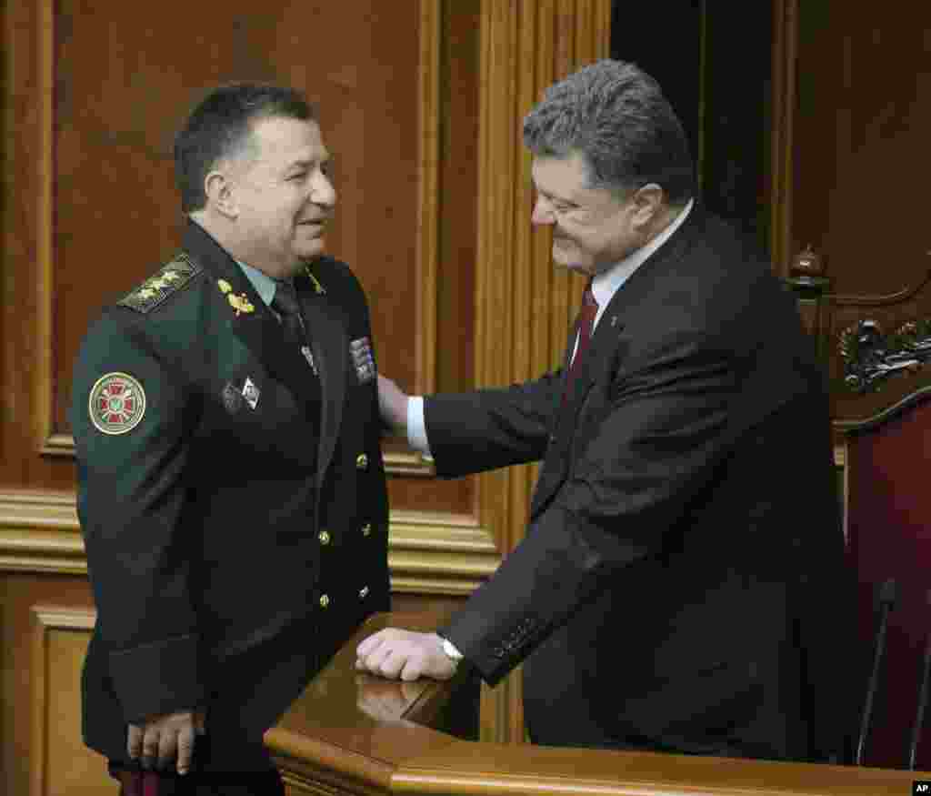 Ukraine's President Petro Poroshenko, right, speaks with new defense minister Stepan Poltorak in parliament in Kiev, Ukraine, Oct. 14, 2014.