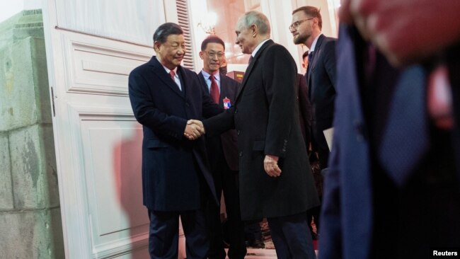 中国国家主席习近平与俄罗斯总统普京在星期二晚宴结束时握手道别。