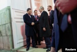 俄罗斯总统普京和中国领导人习近平出席招待会后走出克里姆林宫握手告别。（2023年3月21日）