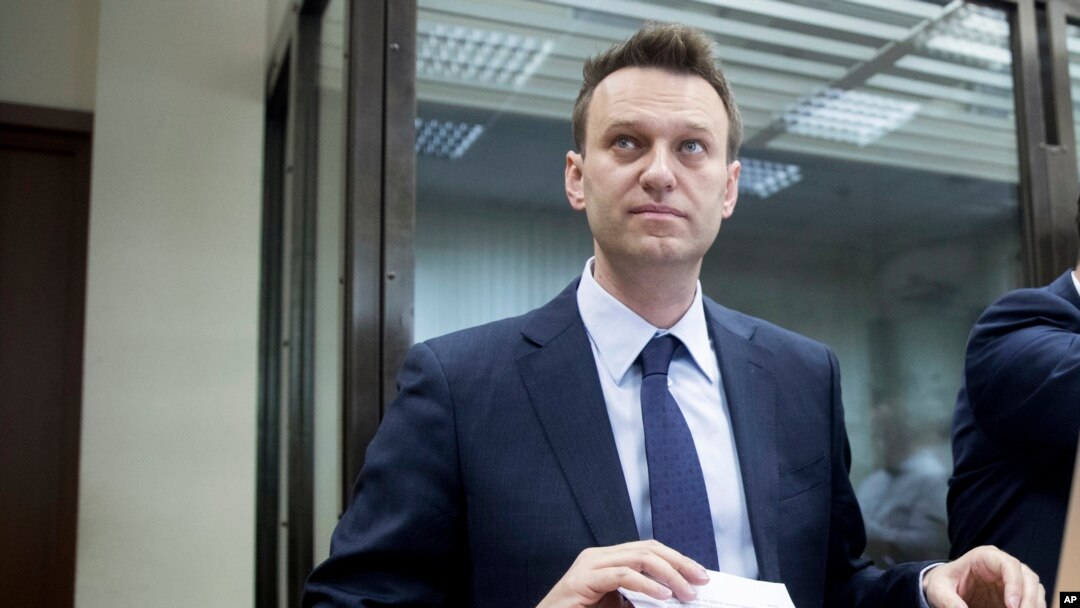 Alexei Navalny memegang koran saat menunggu di ruang pengadilan di Moskow, Rusia, 30 Mei 2017. (AP Photo/Pavel Golovkin, File).