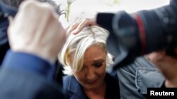 Des gardes du corps protègent la candidate à la présidentielle française Marine Le Pen, cible des œufs lancés par des manifestants lors de son arrivée à Dol-de-Bretagne, France, le 4 mai 2017.