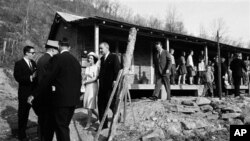Lyndon B. Johnson et son épouse Lady Bird, visitant l'habitation de Tom Fletcher, père de huit enfants au chômage, dans le cadre de la guerre contre la pauvreté