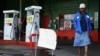 A woman walks past a "No Petrol" sign at a fuel station in Harare, Zimbabwe, Oct. 9, 2018. 