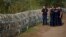Hungarian police inspect a barbed wire fence on the border with Serbia, in Roszke, Hungary, Aug. 29, 2015. 