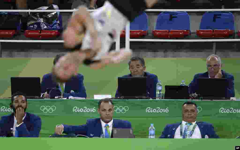 Judges watch Germany's Andreas Bretschneider perform his floor routine during the artistic gymnastics men's qualification at the 2016 Summer Olympics in Rio de Janeiro, Brazil, Aug. 6, 2016. 