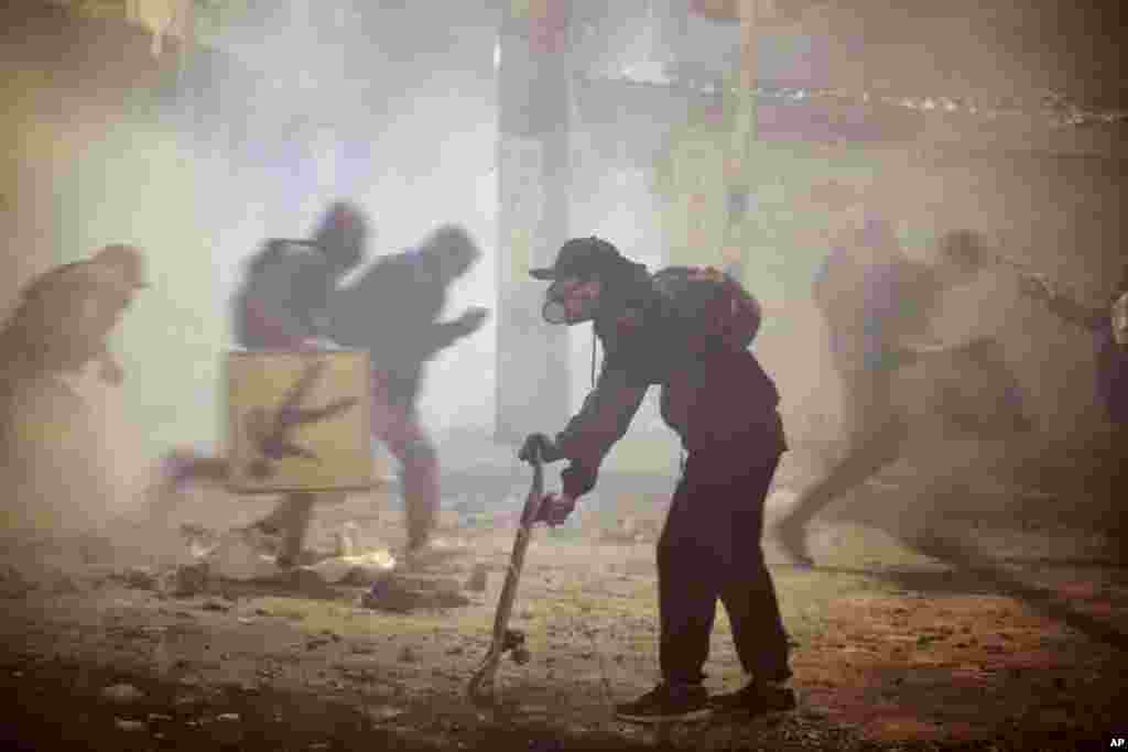 Anti-government protesters run during clashes with the police in Bogota, Colombia, May 26, 2021.