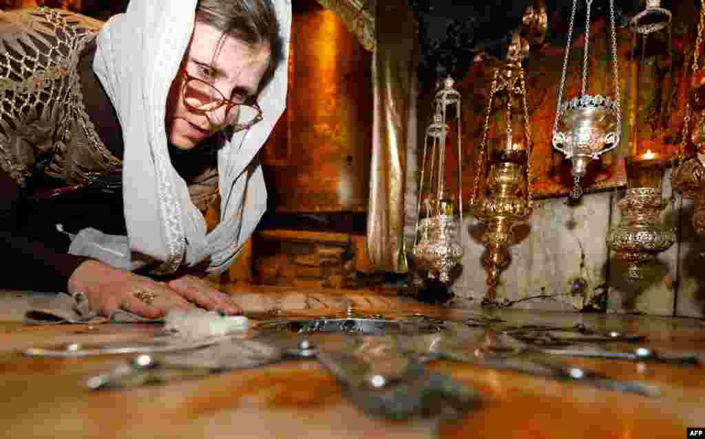 A Christian worshipper kisses a 14-pointed silver star, believed to be the exact spot where Jesus Christ was born, at the grotto in the Church of the Nativity in the biblical West Bank city of Bethlehem.
