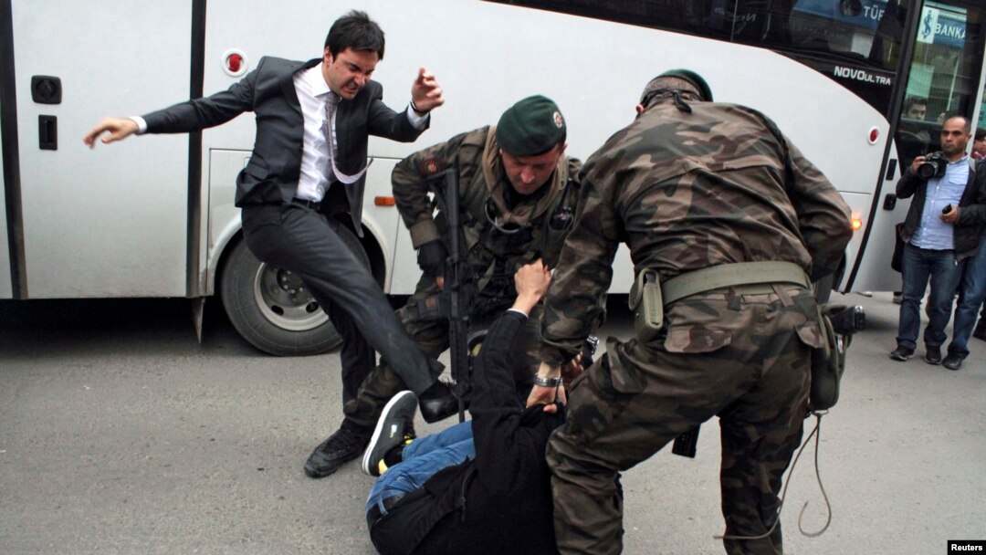 Seorang demonstran ditendang oleh Yusuf Yerkel (kiri), penasihat Perdana Menteri Recep Tayyip Erdogan, saat polisi menahan demonstran itu dalam protes melawan kunjungan Erdogan di Soma (14/5). 