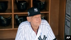 FILE - New York Yankees' Don Larsen sits in the dugout before the Yankees' Old-Timers' Day baseball game at Yankee Stadium in New York, June 17, 2018. Larsen, who threw a perfect game and only no-hitter in World Series history, died Jan. 1, 2020.