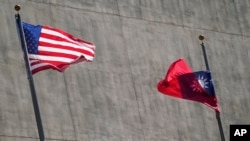 FILE - A U.S. and a Taiwanese flag flutter outside a hotel as Taiwan's president was staying in Los Angeles, California, April 4, 2023. (AP Photo/Damian Dovarganes, File)