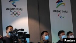 Periodistas frente a los carteles de los Juegos Olímpicos de Invierno de Beijing 2022 durante una conferencia sobre el progreso de la construcción de las sedes, en la sede del Comité Organizador de Beijing, el 30 de julio del 2021.