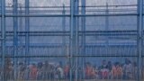 Reclusos son retenidos en el patio de una prisión después de un motín mortal en Latacunga, Ecuador, el martes 4 de octubre de 2022. 
