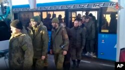 Un grupo de soldados rusos desciende del autobús, en un lugar sin especificar, tras un intercambio de prisioneros entre Moscú y Kiev, el 6 de diciembre de 2022.