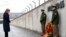FILE - German Chancellor Angela Merkel observes a moment of silence as she lays a wreath during a ceremony at the memorial in the former Nazi concentration camp in Dachau, near Munich, May 3, 2015, to mark the 70th anniversary of the liberation of the camp.