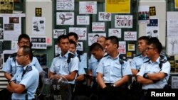 Policemen stand in front of messages left by pro-democracy protesters outside a HSBC branch off a blocked road at Mongkok shopping district in Hong Kong, Oct. 17, 2014.