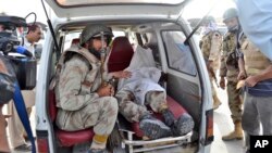 A Pakistani paramilitary soldier sits in the back of a vehicle next to the lifeless body of his colleague who was killed by gunmen during a gun battle at a hospital, in Quetta, Pakistan, June 15, 2013.