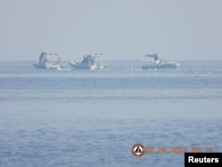 Kapal-kapal Garda Pantai China berlayar dekat penghalang apung tak jauh dari laguna Scarborough Shoal, 24 September 2023. (Foto: Garda Pantai Filipina via Reuters)